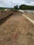 Dairy farm feed pad without grooved concrete